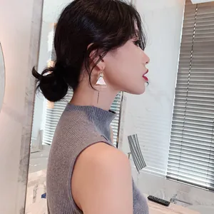 Elegant asymmetric geometric triangle tassel earrings for women worn by an Asian model.