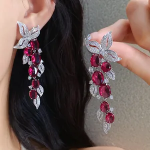 Detailed shot of heavy-duty zircon leaf tassel earrings with sparkling red gemstones