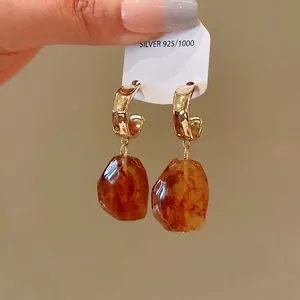 Maillard style amber resin drop earrings with irregular gold pleated hoops.