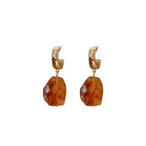 Retro Maillard earrings with irregular gold crumpled metal posts and amber resin drops