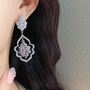 Close-up of luxury sparkling cubic zirconia drop earrings with floral frame design