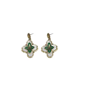 Elegant vintage flower drop earrings with white and green enamel in retro gold finish