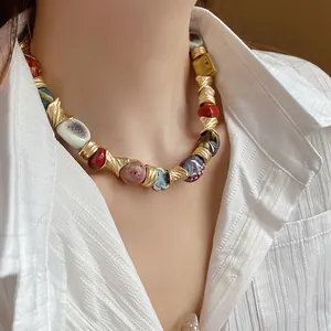 Vintage irregular colorful ceramic beaded necklace with gold-toned metal accents on model