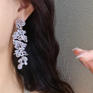 Elegant silver-toned zircon leaf tassel earrings shown on an Asian female model