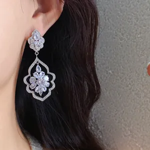 Close-up detail showing sparkly zircon earrings in an ornate silver-toned frame on the ear.