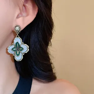 Detailed close-up of elegant vintage palace style flower earrings worn by a model