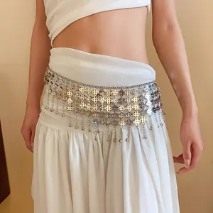 Détail d'une chaîne de taille bohème en métal argenté avec franges et clochettes sur une jupe.