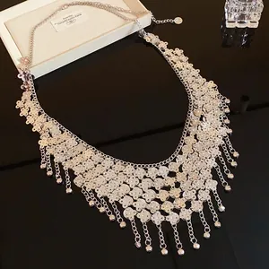 Détail d'un collier plastron vintage en métal argenté avec disques et glands de billes