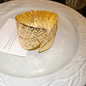 Detailed view of the intricate leaf vein texture on a gold-plated cuff bracelet.