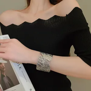 Macro detail of a minimalist silver leaf cuff bracelet with intricate textured vein patterns