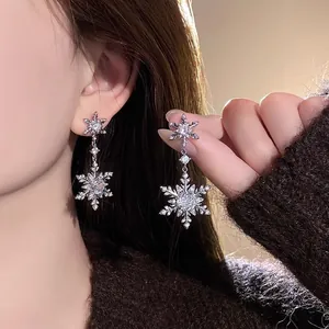 Close-up of elegant silver needle snowflake earrings with shimmering zircon stones