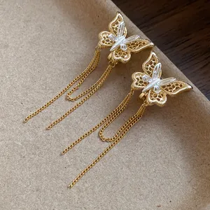 Vista dettagliata di orecchini a clip a farfalla placcati in oro 18k con catene a nappa