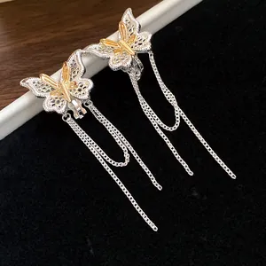 Dettaglio degli orecchini a clip a farfalla placcati oro 18k con lunghe nappe e catene