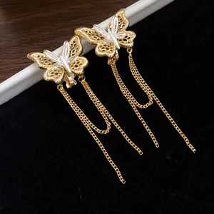 Dettaglio di orecchini a clip a farfalla placcati oro 18k con lunghe catenelle