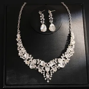 Elegant silver-tone crystal necklace and waterdrop earring set displayed on black box.