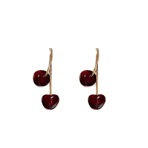 Elegant vintage red resin cherry stud earrings with gold-tone metal stems, white background