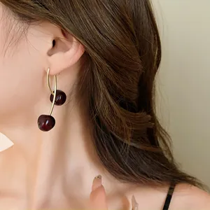 Elegant close-up shot showing the wearing effect of retro dark red cherry resin earrings