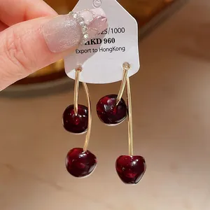 Detailed close-up showing the high-gloss finish of vintage red resin cherry drop earrings