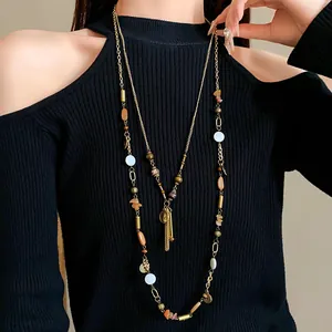 Close-up of retro ethnic layered necklace with ceramic beads and human figure pendant