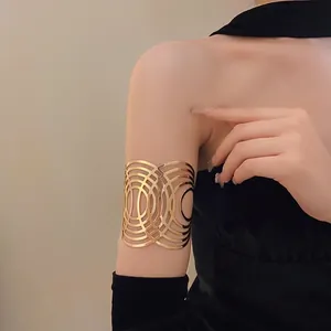 Goldener breiter Metall-Oberarmreif mit elegantem filigranem konzentrischem Design