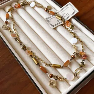 Close-up of vintage ethnic style long necklace with orange stones and shell beads in a box