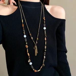 Detailed shot of a vintage layered necklace featuring ceramic beads and portrait charms