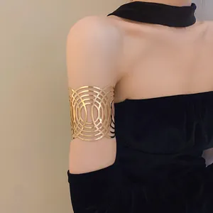 Detaillierte Ansicht einer geometrischen goldenen Metall-Armmanschette am Oberarm