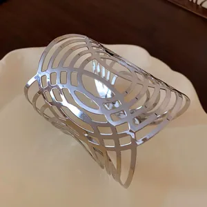 Detailansicht der polierten silbernen Metallmanschette mit elegantem Gitter-Hohlmuster