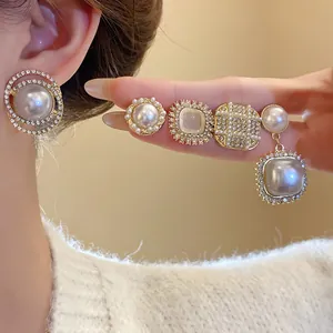 Macro view of elegant geometric silver needle pearl earrings with sparkling crystals