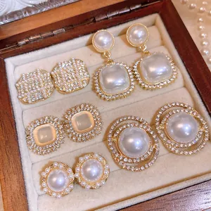 Detailed view of assorted vintage pearl and rhinestone earrings in a wooden box