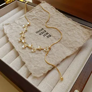 Gros plan d'un collier plaqué or avec de délicates fleurs en nacre et des perles