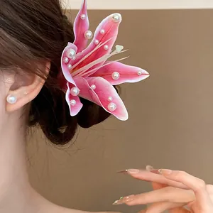 Close-up detail of a sweet pink fabric lily hair clip adorned with pearls on a bun