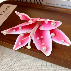 Close-up of pink fabric lily hair clip with delicate white pearl embellishments