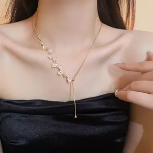 Collier floral élégant plaqué or avec strass et perles porté par un mannequin