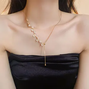 Vue détaillée d'un élégant collier floral plaqué or porté par un mannequin féminin.