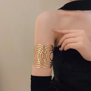 Detail eines goldenen Armreifs aus Metall mit einem aufwendigen geometrischen Muster