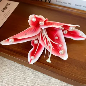 Close-up of pink fabric lily hair clip with elegant white pearl embellishments