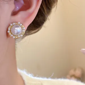 Detailed macro view of elegant French retro pearl earrings with silver needle on ear