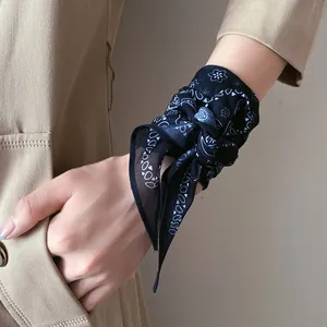Gros plan d'un foulard en soie vintage français noué comme un accessoire de poignet chic.