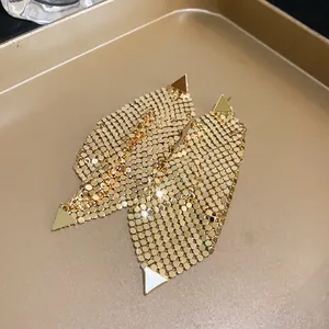 Close-up of gold triangular sequin mesh dangling earrings showing metallic texture