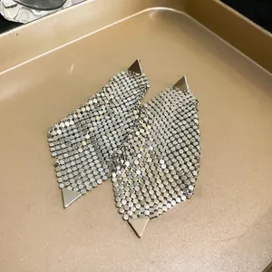 Detailed macro shot of stylish silver sequin irregular earrings with modern triangle accents