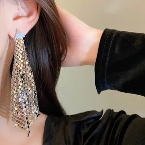 Detailed view of fashionable silver sequin mesh triangle drop earrings worn by a model