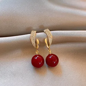 Elegant red drop earrings with gold-tone finish and clear sparkling stones
