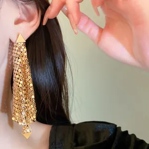 Close-up detail of stylish gold sequin triangle tassel dangle earrings worn by model