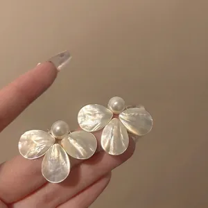 Close-up of French retro shell petal earrings with pearls, showing elegant texture