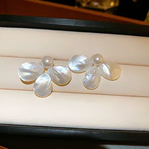 Detailed view of mother-of-pearl petal earrings with lustrous central pearl in box