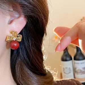 Vintage 18k gold plated flower stud earrings with red pearl drop on model