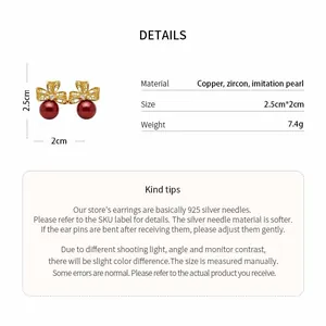 Close-up detail of vintage 18k gold plated bow stud earrings with a dangling red pearl