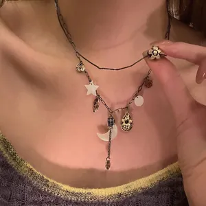 Detail view of a vintage punk distressed metal necklace with moon and star charms