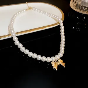 Elegant pearl necklace with a shiny gold-toned bow pendant for stylish women jewelry